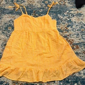 A orange and white plaid sundress with tie straps.